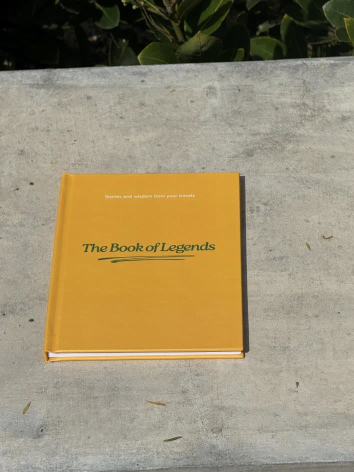 The Book of Legends lying on a concrete bench, the whole hardcover in view